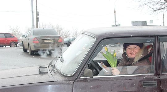 Сотрудники госавтоинспекции вручают женщинам-водителям цветы и специальные фликеры